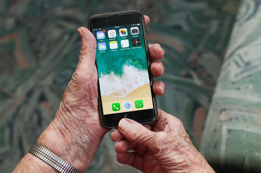 Bilde: Gammel hånd som holder i en mobil
